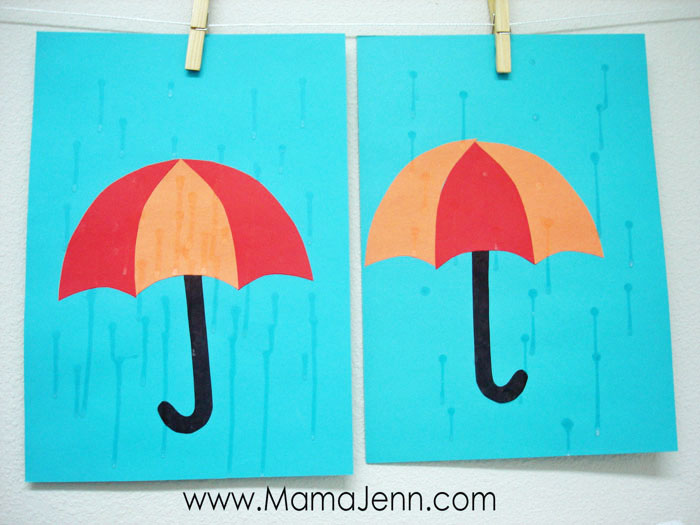 blue construction paper with red and orange umbrella craft with dry glue as raindrops