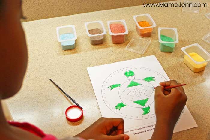 child doing an art project using colored sand